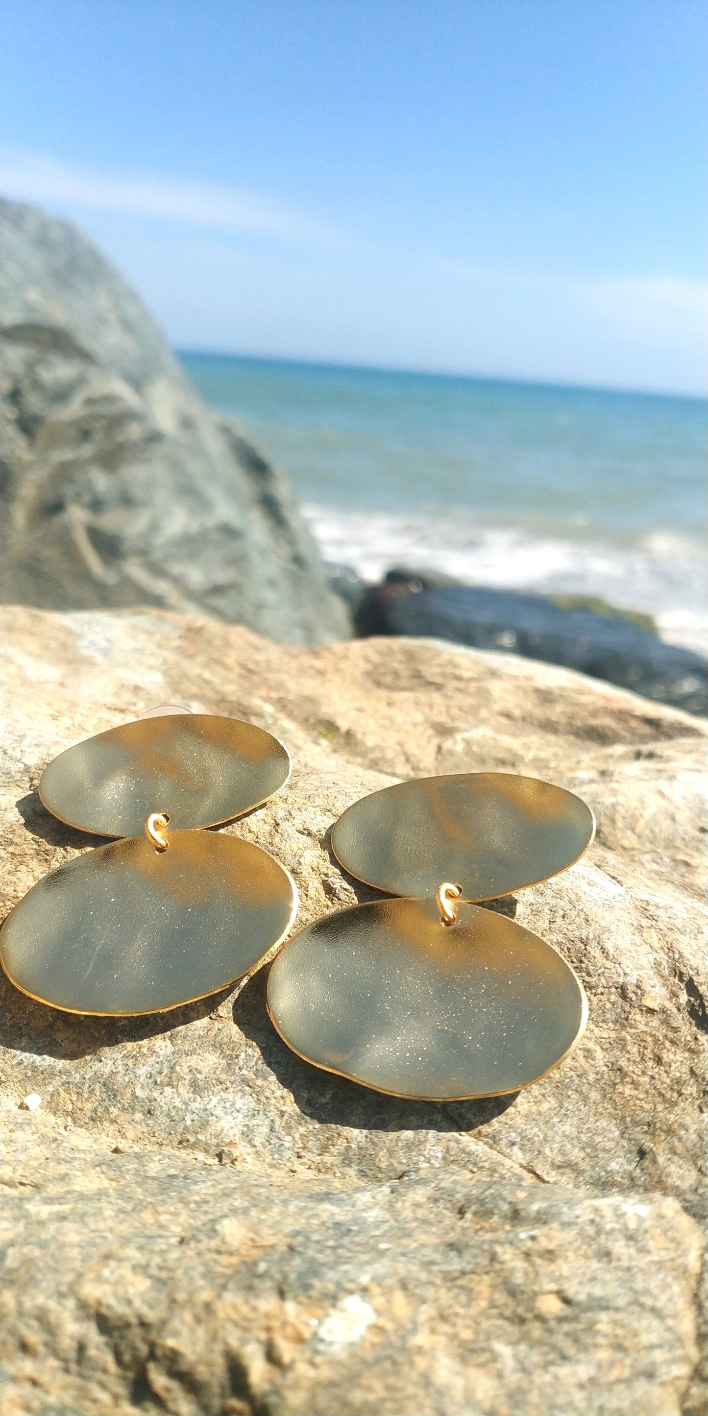 Heliades Earrings – Greek Hammered Jewelry – Available in 18K Gold, Silver, and Rose Gold Plated. Radiant hammered circular discs inspired by the daughters of the Sun.