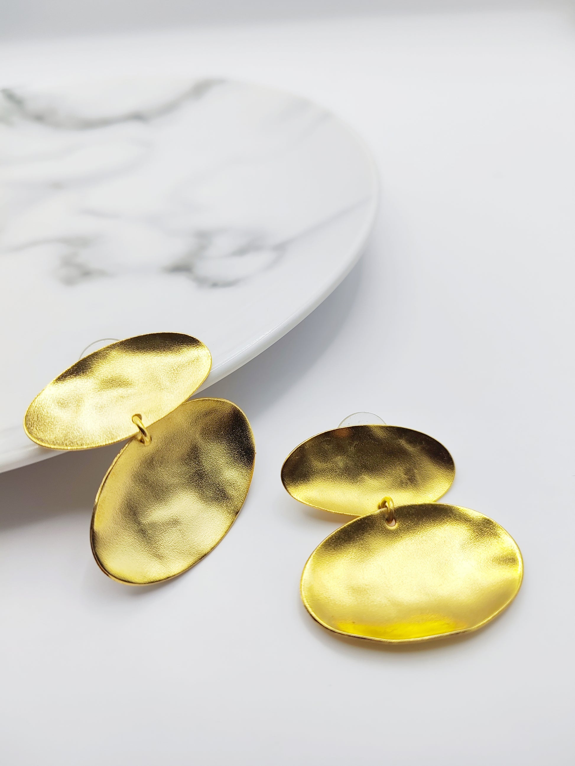 Heliades Earrings – Greek Hammered Jewelry – Available in 18K Gold, Silver, and Rose Gold Plated. Radiant hammered circular discs inspired by the daughters of the Sun.