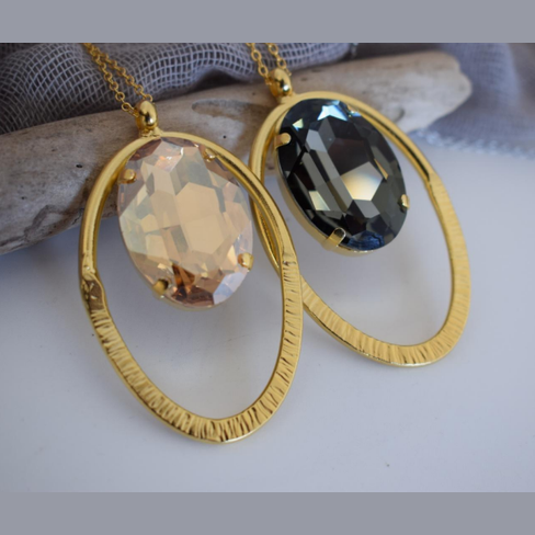 Andromeda Necklace With Crystal – Greek Hammered Jewelry – 18K Gold, Silver, or Rose Gold Plated. Oval hammered pendant with luminous crystal centerpiece.