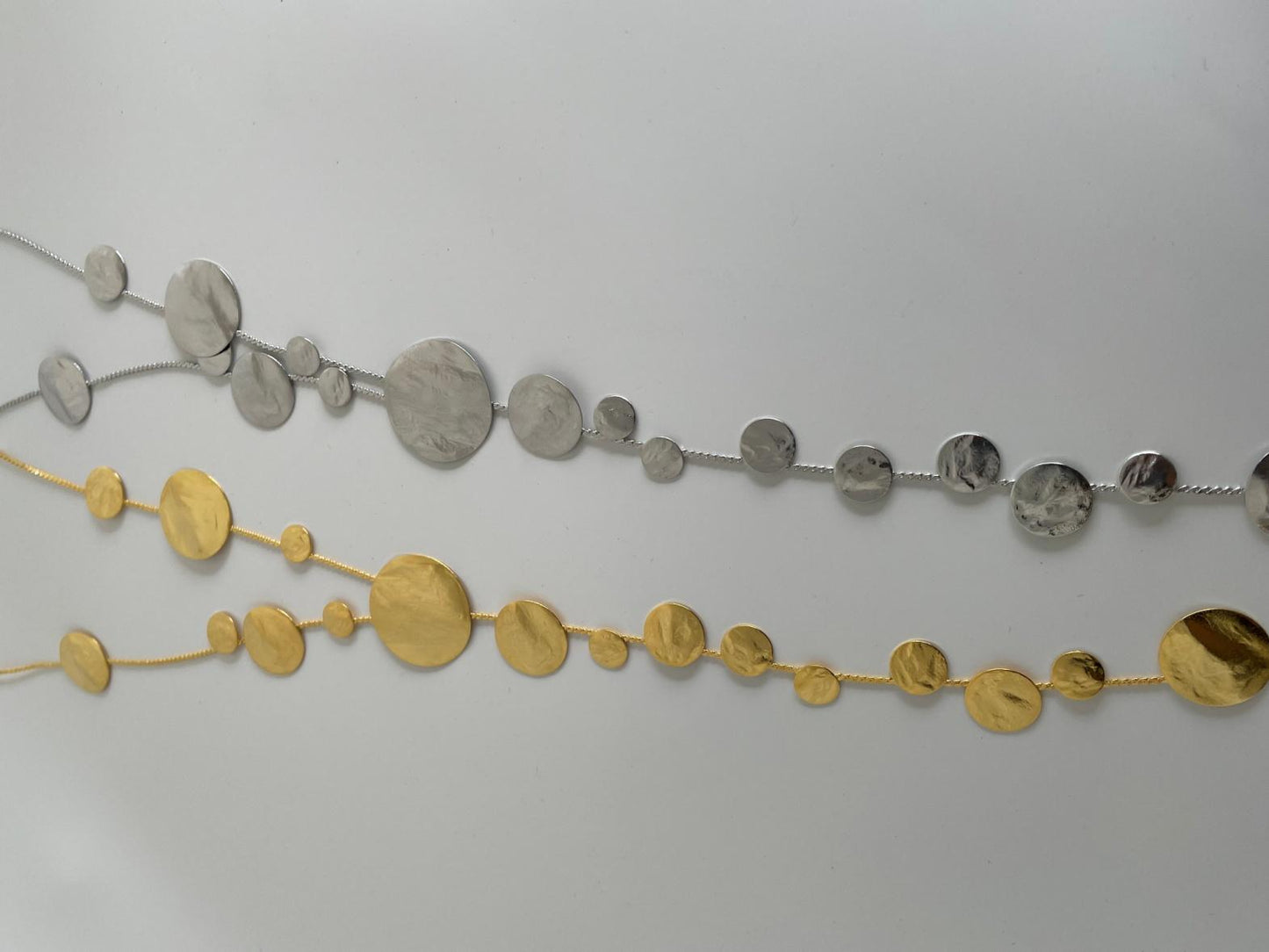 Ampelos necklace – Greek hammered jewelry with cascading hammered discs resembling grape clusters, available in 18K gold-plated, 18K silver-plated, and rose-gold plated finishes.