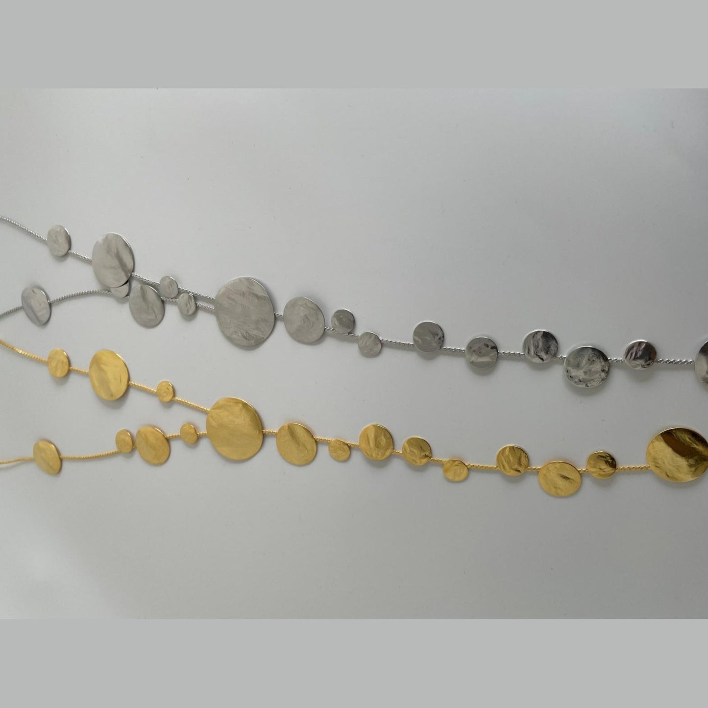 Ampelos necklace – Greek hammered jewelry with cascading hammered discs resembling grape clusters, available in 18K gold-plated, 18K silver-plated, and rose-gold plated finishes.