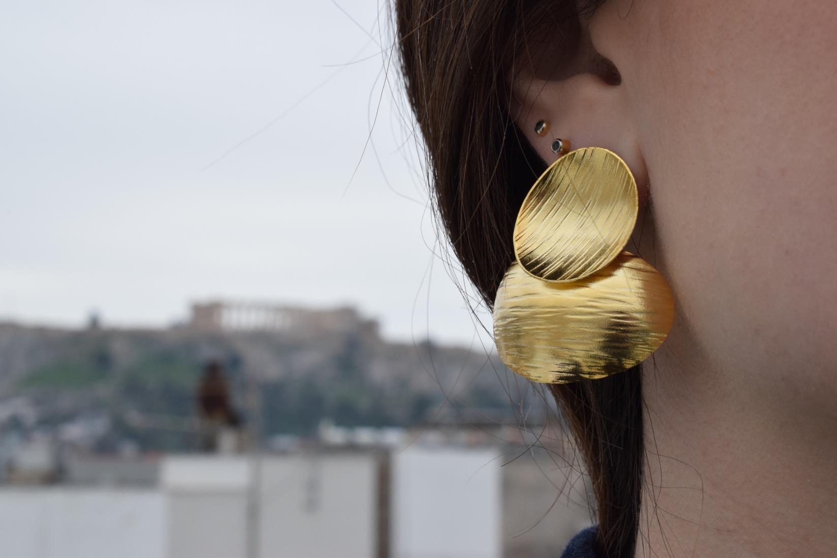 Ostraka earrings – Greek hammered jewelry with bold round textured discs, inspired by ancient Greek pottery shards, available in 18K gold-plated, 18K silver-plated, and rose-gold plated finishes.