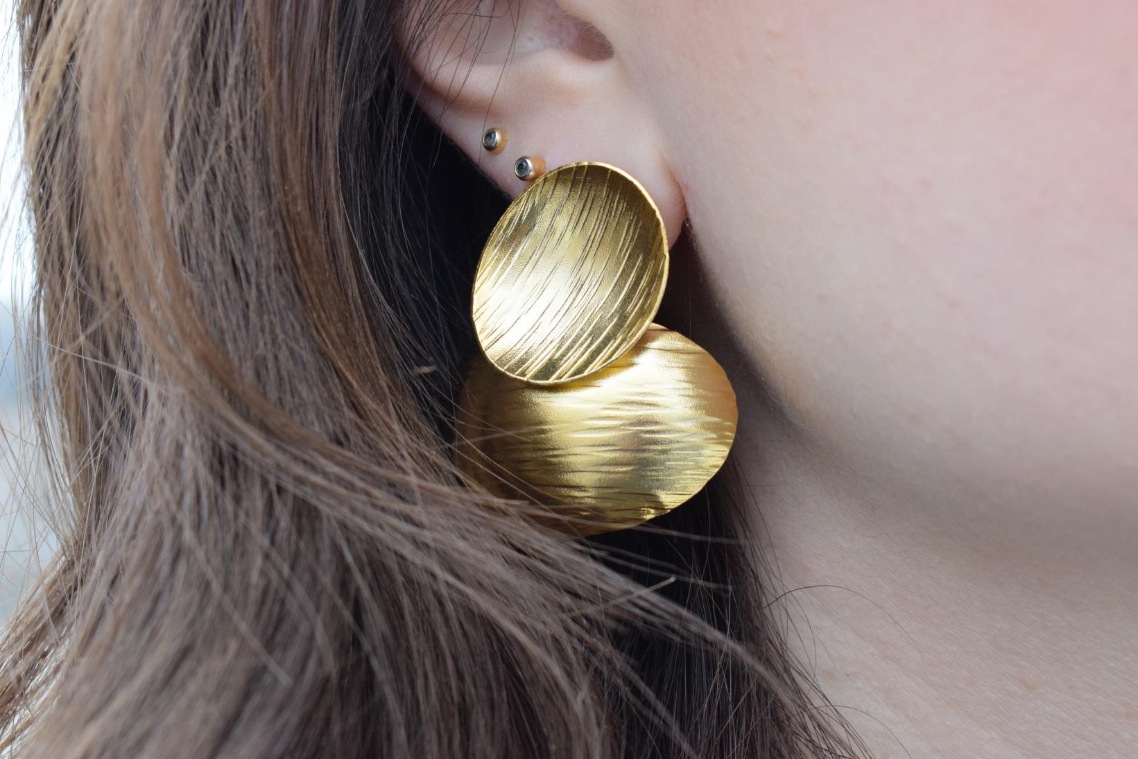 Ostraka earrings – Greek hammered jewelry with bold round textured discs, inspired by ancient Greek pottery shards, available in 18K gold-plated, 18K silver-plated, and rose-gold plated finishes.