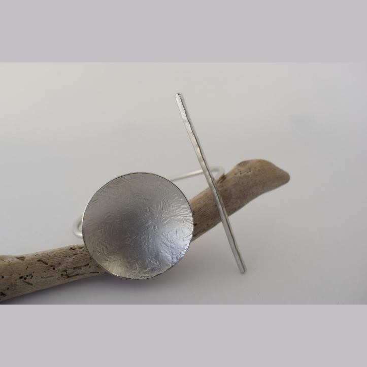 Handmade open cuff bracelet with hammered disc and vertical bar inspired by the ancient Greek concept of the axis of balance, available in gold, silver, or rose gold plating.