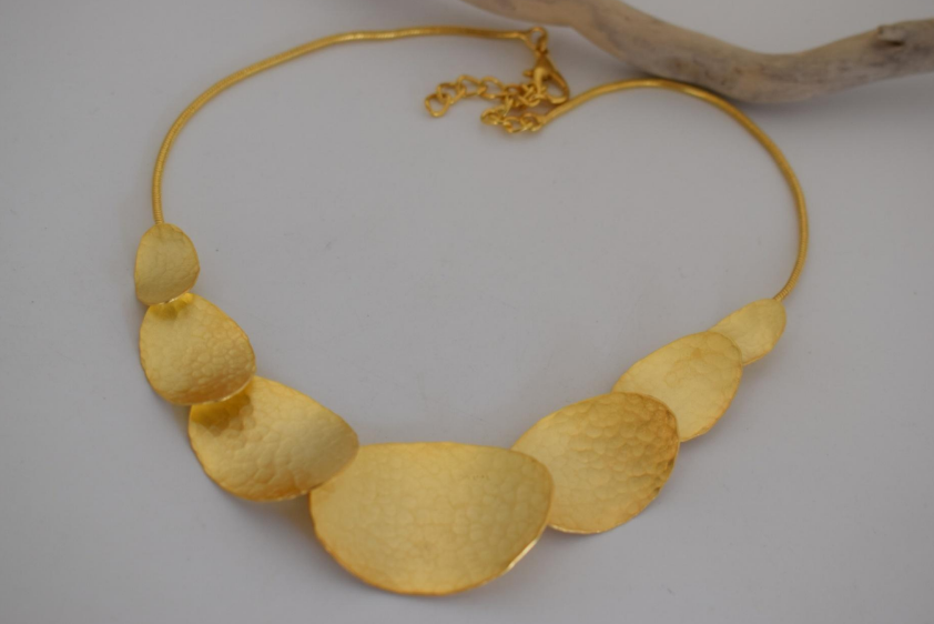 Handmade hammered necklace with gold-plated organic shapes inspired by Gaia, the Greek goddess of the Earth.