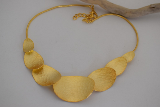 Handmade hammered necklace with gold-plated organic shapes inspired by Gaia, the Greek goddess of the Earth.