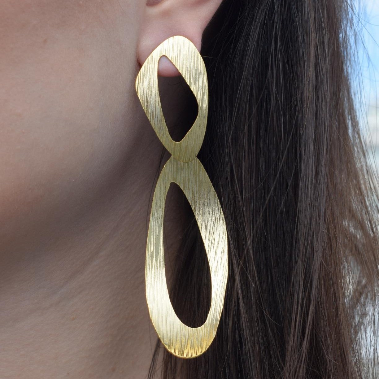 Ostraka earrings in Greek hammered open oval design, available in 18K gold plated and 18K silver plated finishes.
