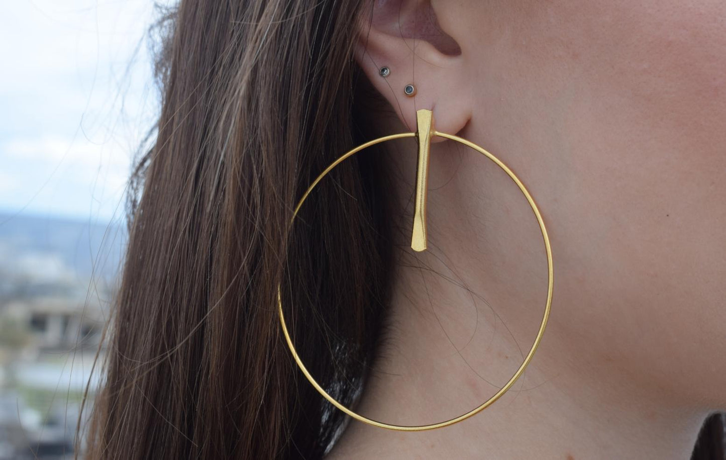 Elysia earrings in Greek hammered hoop design, available in 18K gold plated and 18K silver plated finishes.