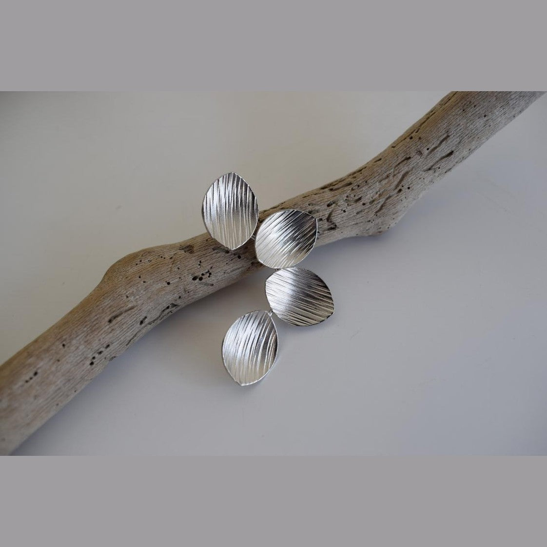Anemone handmade Greek hammered earrings with petal-inspired elements, available in gold and silver plated finishes.