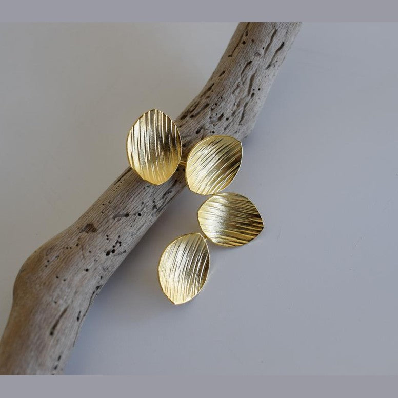 Anemone handmade Greek hammered earrings with petal-inspired elements, available in gold and silver plated finishes.