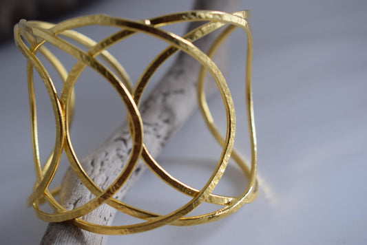 Thetis bracelet – Greek hammered jewelry with openwork wave-inspired design, available in 18K gold-plated, 18K silver-plated, and rose-gold plated finishes.