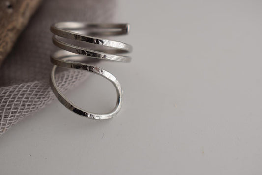 Ocean ring Greek hammered jewelry with spiral wave-inspired design, available in gold, silver, and rose gold plated.