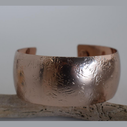 Handmade wide cuff bracelet with hammered texture inspired by the Aegis shield of Zeus and Athena, available in gold, silver, or rose gold plating.
