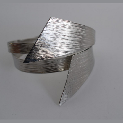 Handmade sculptural wrap bracelet with textured finish inspired by the draped folds of the ancient Greek chiton garment, available in gold, silver, or rose gold plating.