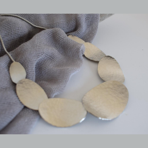 Handmade hammered necklace with gold-plated organic shapes inspired by Gaia, the Greek goddess of the Earth.